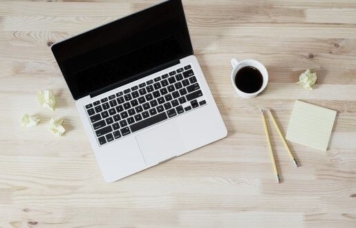 Draufsicht auf MacBook, Kaffeetasse und Post-its.