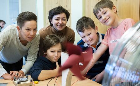 Zwei Firstcon-Mitarbeiterinnen und drei Schüler an der Windenergie-Station des mobilen Energielabors vom SCHUBZ in Kooperation mit Firstcon.