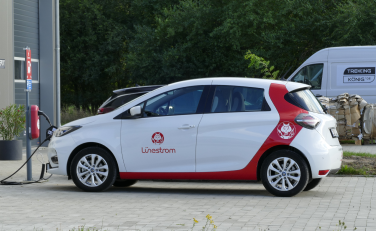 Lünestrom gebrandetes Auto lädt an einer E-Ladesäule